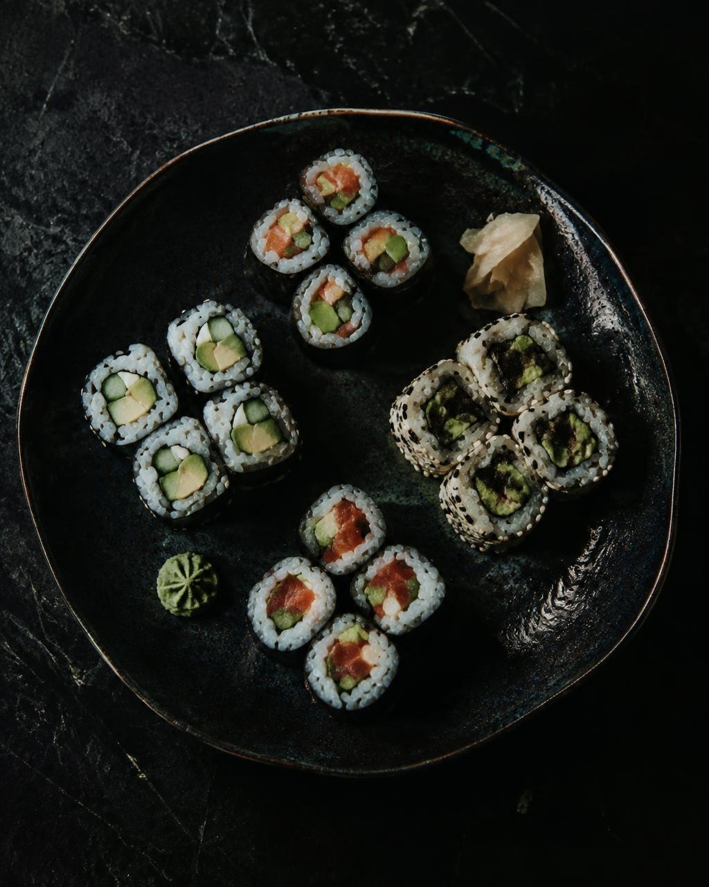 Auswahl an Maki-Rolls auf dunkler Keramik
